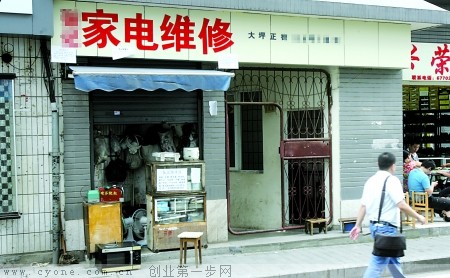 昨日，大坪，市民经过一家电维修店。记者 蒋雨龙 实习生 段岩 摄